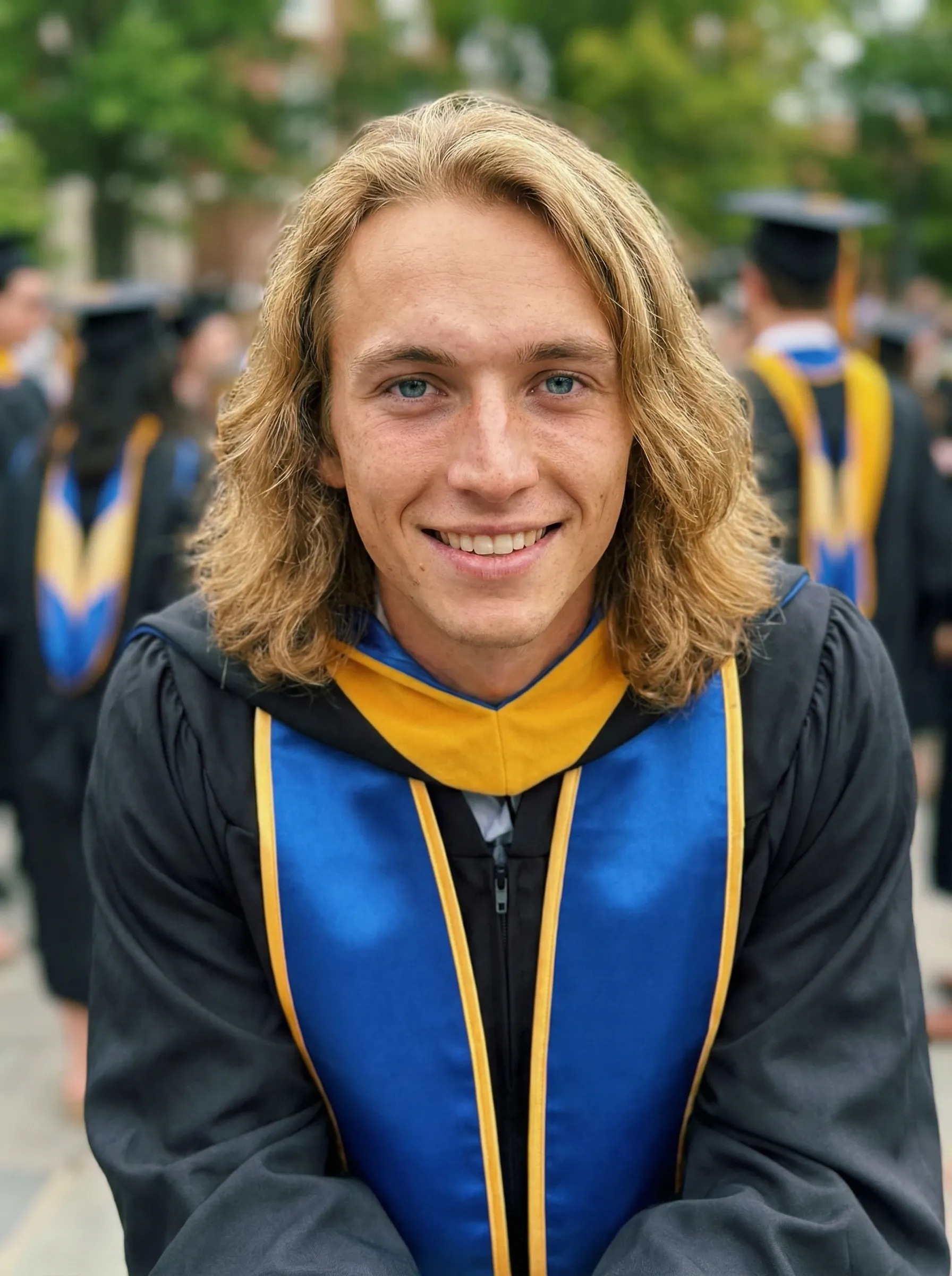 AI graduation headshot — young man in a graduation gown with a blue and gold hood at commencement